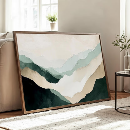 a large framed painting of mountains with a soothing color palette of green, beige, and white. The painting is displayed on a wooden floor in a living room setting, with a couch and a small table nearby.