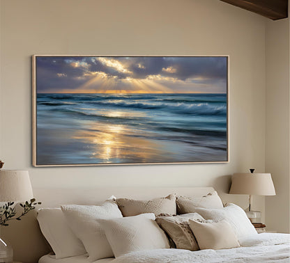 a large framed painting of a serene beach scene with waves crashing against the shore, set against a backdrop of a cloudy sky with sunbeams shining through.