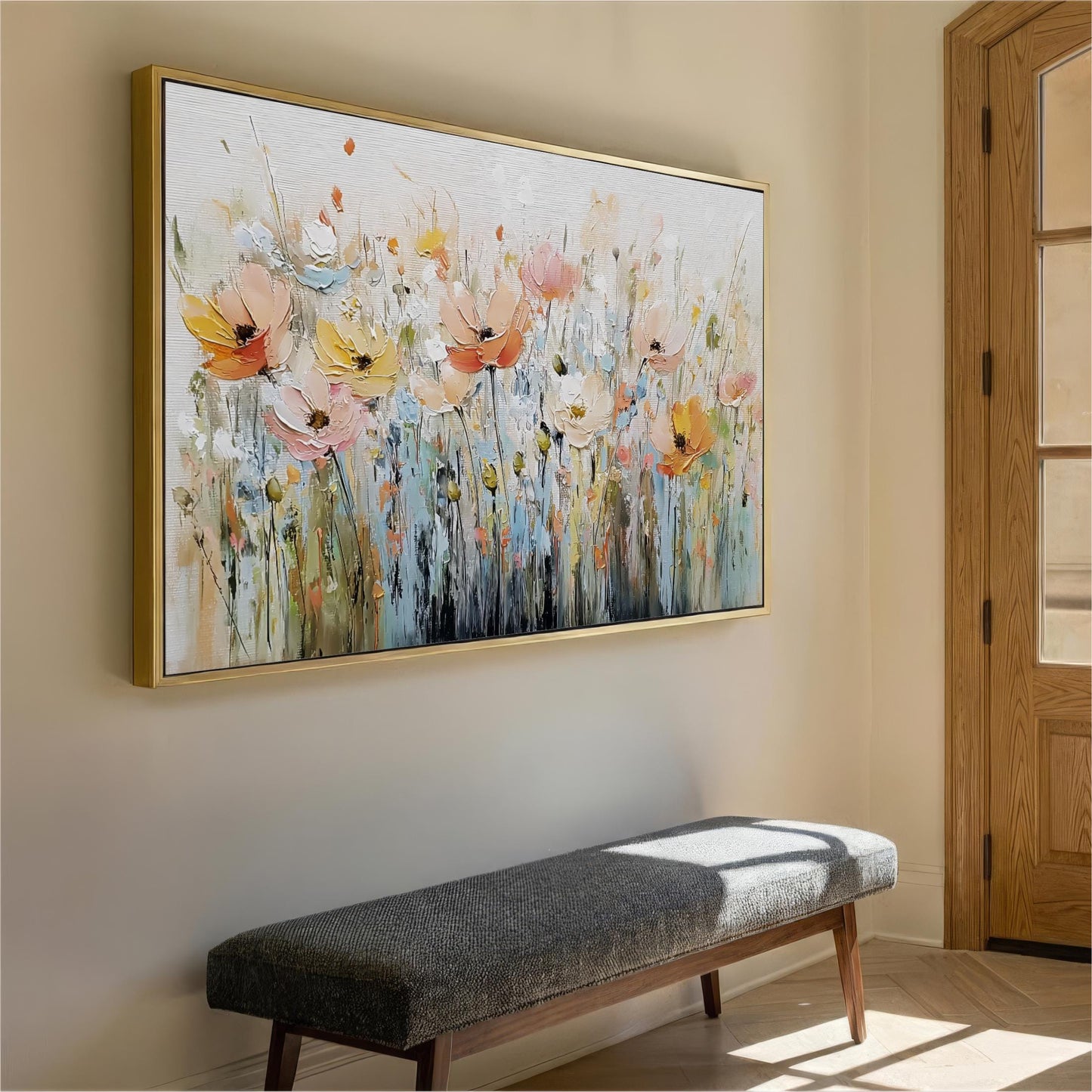 a large, colorful painting of flowers hanging on a wall, with a gray bench placed in front of it.