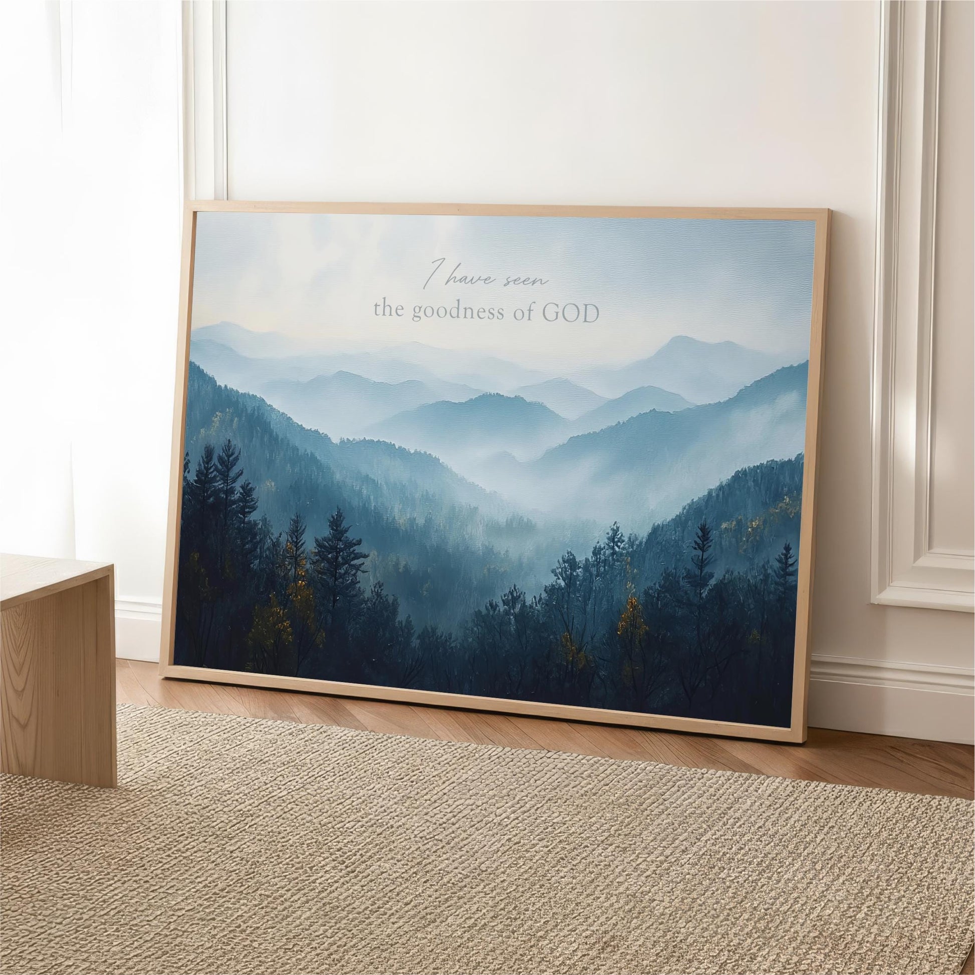 The image is a framed poster of a mountainous landscape with a forested area in the background.