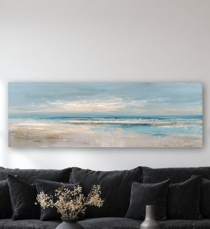 a large landscape painting hanging on a wall above a black couch with decorative pillows.