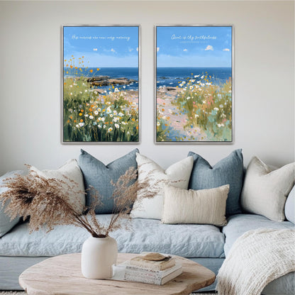 a cozy living room with a blue couch, a coffee table, and two framed paintings of a serene landscape with a field of flowers and a body of water.
