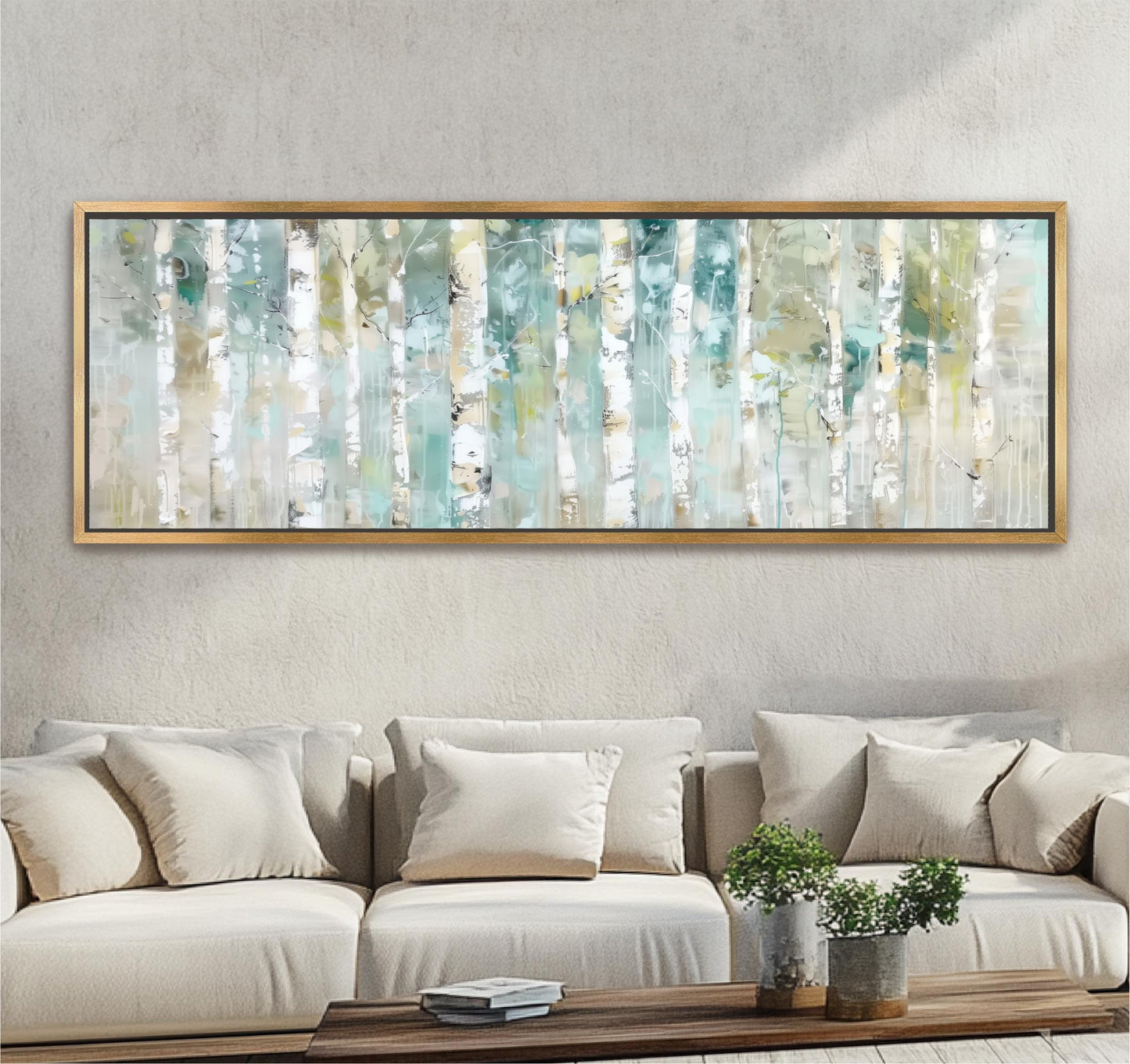 a large, framed painting of birch trees hanging on a wall above a beige sofa with white pillows. The painting is displayed in a gold frame, and the sofa is positioned in front of it, creating a cozy and inviting atmosphere in the room.