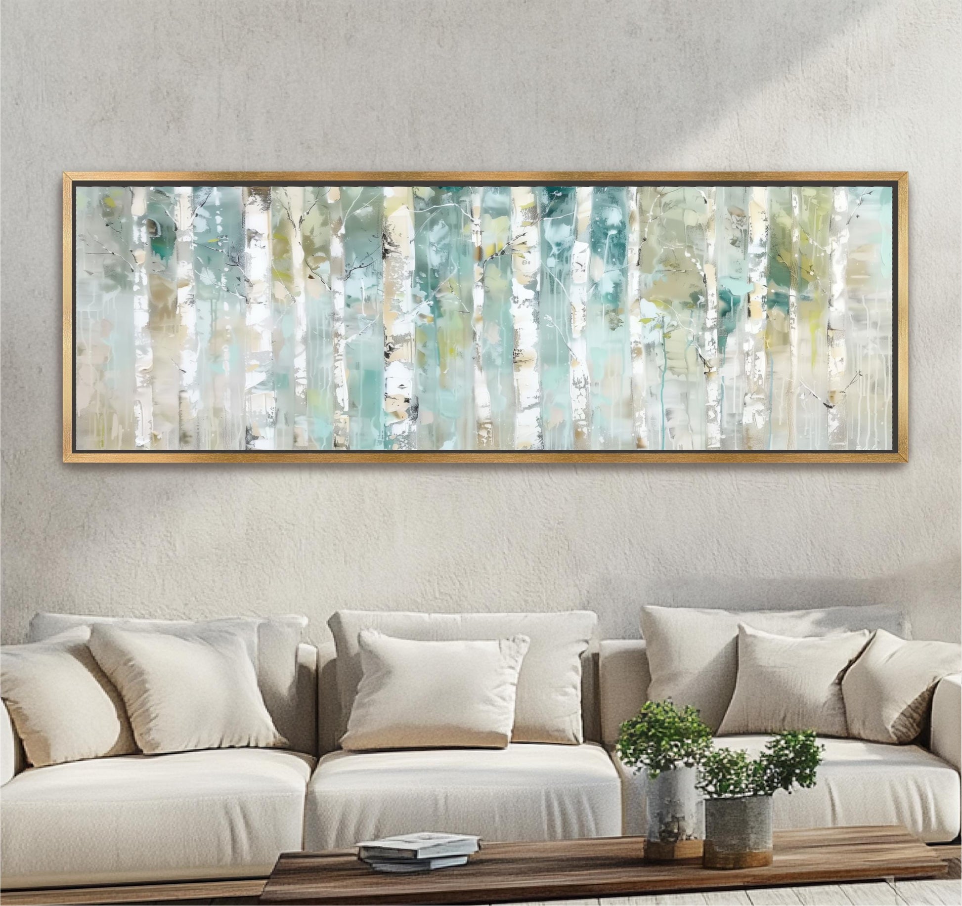 a large, framed painting of birch trees hanging on a wall above a beige sofa with white pillows. The painting is displayed in a gold frame, and the sofa is positioned in front of it, creating a cozy and inviting atmosphere in the room.