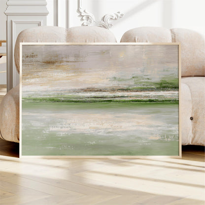 a large abstract painting displayed on a wooden floor in front of a beige sofa.