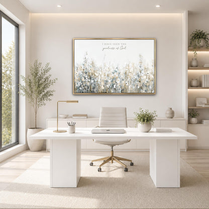 A modern and minimalist office space with a large window, a white desk, a white chair, and a framed artwork depicting a field of flowers.