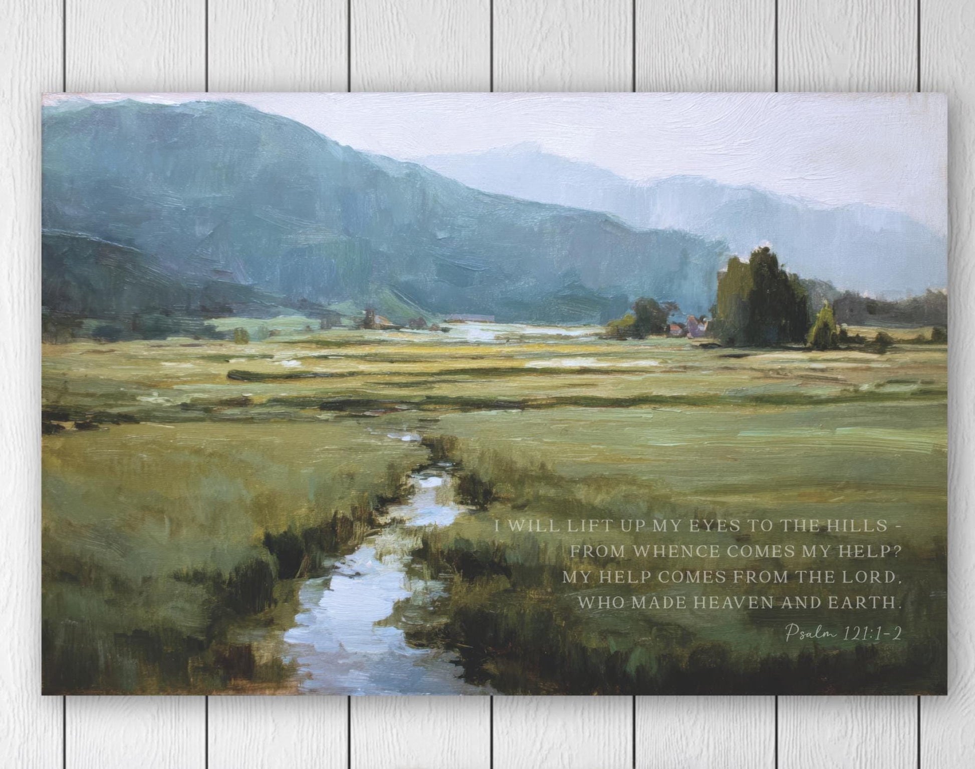 The image is a large painting depicting a serene landscape with a winding stream, lush green fields, and distant mountains. The painting is hung on a wall above a wooden bench, creating a peaceful and tranquil atmosphere.