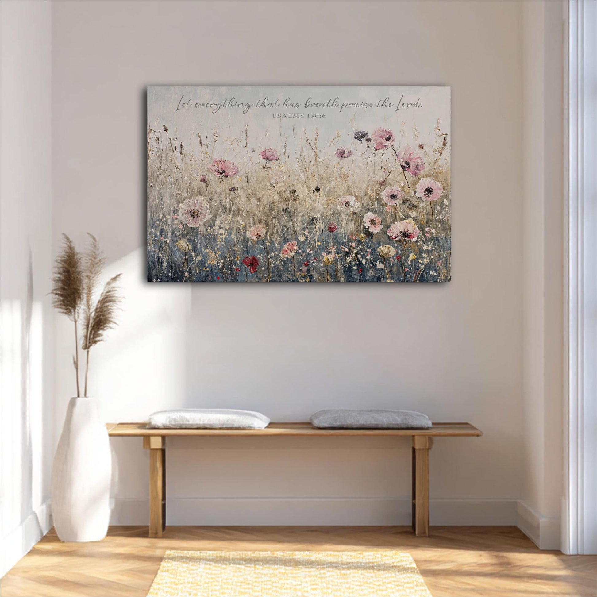 a large floral painting hanging on a white wall above a wooden bench with two cushions.