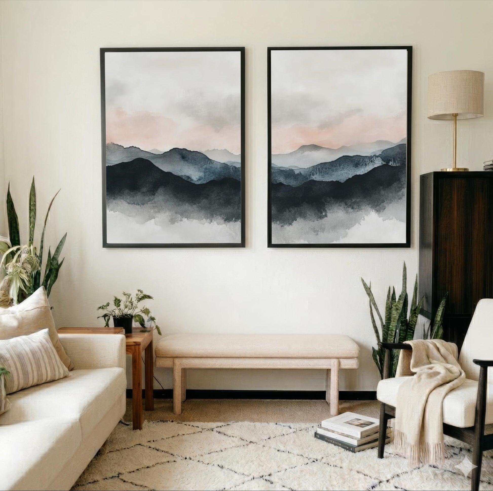a cozy living room with two large framed watercolor paintings of mountains hanging on the wall. The room is furnished with a white sofa, a wooden side table, and a beige armchair. The space is decorated with potted plants and a rug, creating a warm and inviting atmosphere.