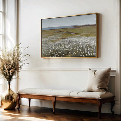a large painting of a field with white flowers hanging on a white wall above a wooden bench with a beige cushion.