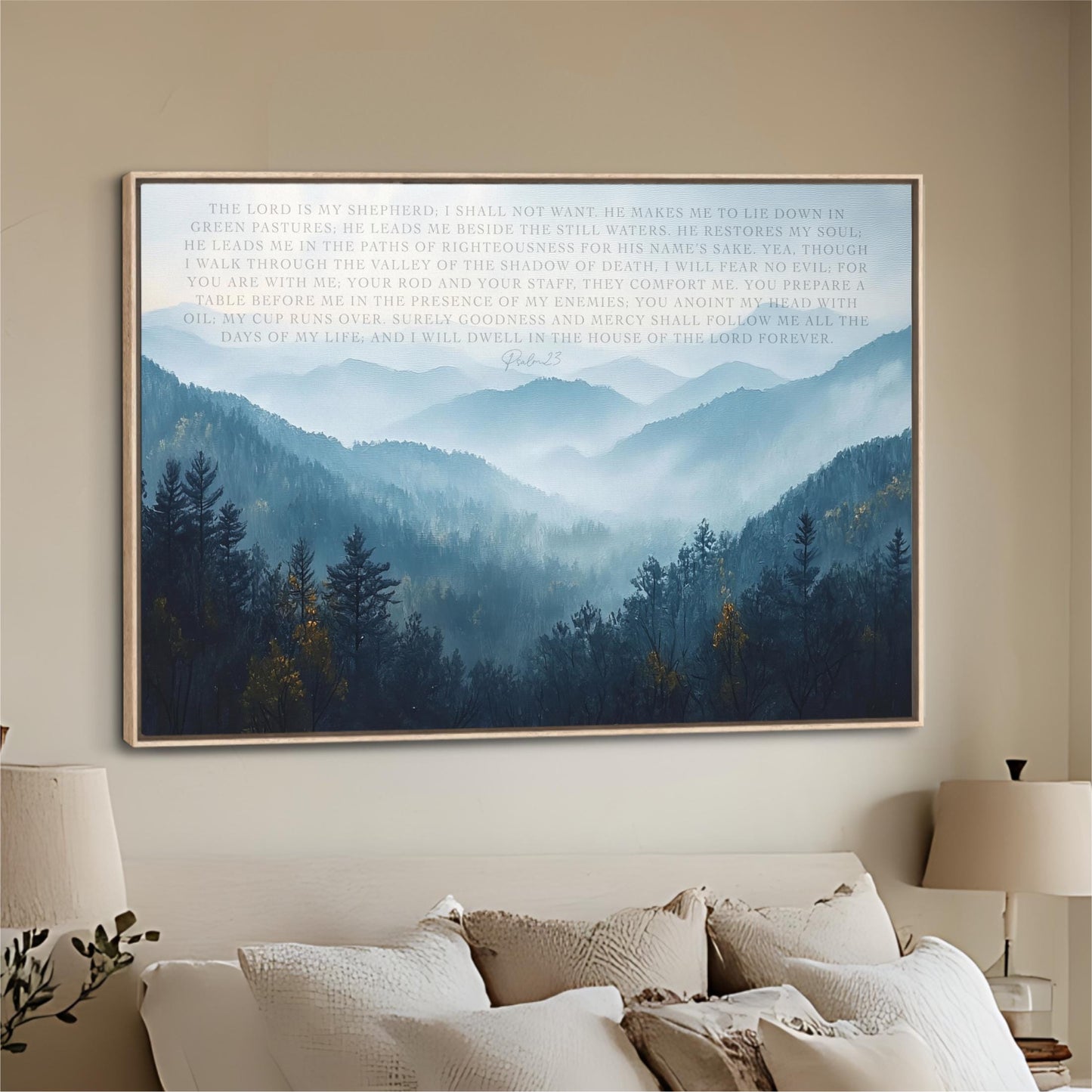 a large framed poster of a serene mountain landscape with trees and fog, hanging on a wall above a bed with white pillows.