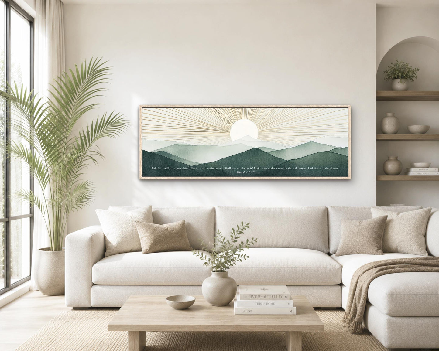 a serene living room with a large white sofa, a wooden coffee table, and a framed landscape painting of a sunrise over mountains. The painting is hung on the wall above the sofa, creating a focal point in the room. The room is decorated with potted plants, vases, and books, adding a cozy and inviting atmosphere.