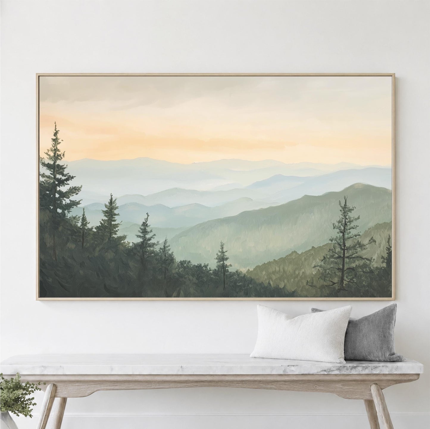 a large framed painting of a mountain landscape with pine trees and a hazy, golden sky above.