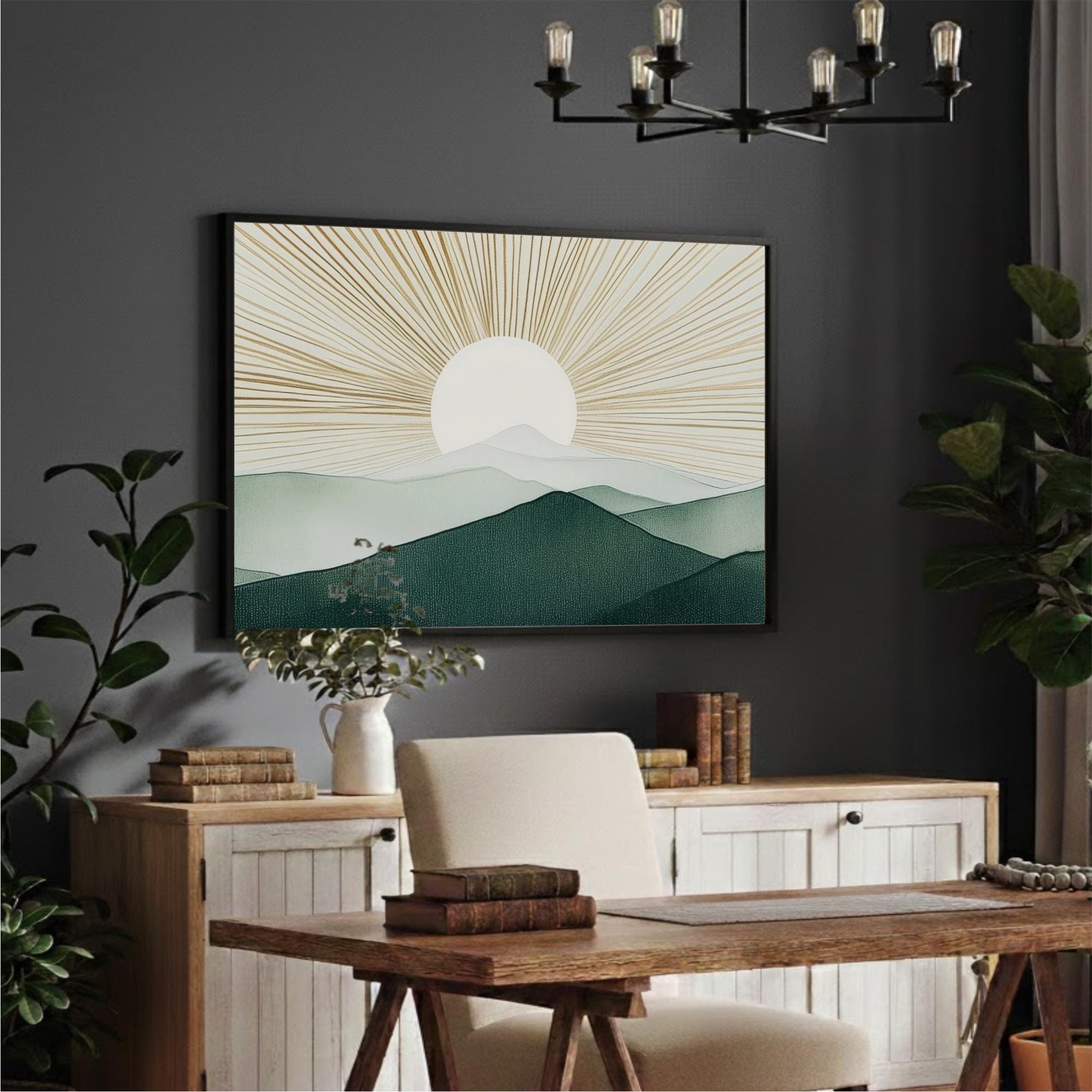 a serene and modern office space with a large framed landscape painting depicting a sun-filled mountain scene hanging on the wall above a wooden desk. The desk is surrounded by a white chair and has a stack of books and a plant on it. The room is decorated with several potted plants and a chandelier, creating a calm and inviting atmosphere.