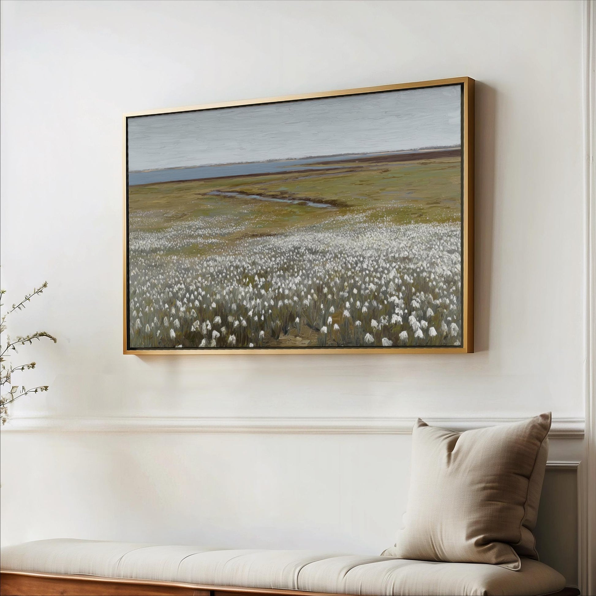 a large painting of a field with white flowers hanging on a white wall above a wooden bench.