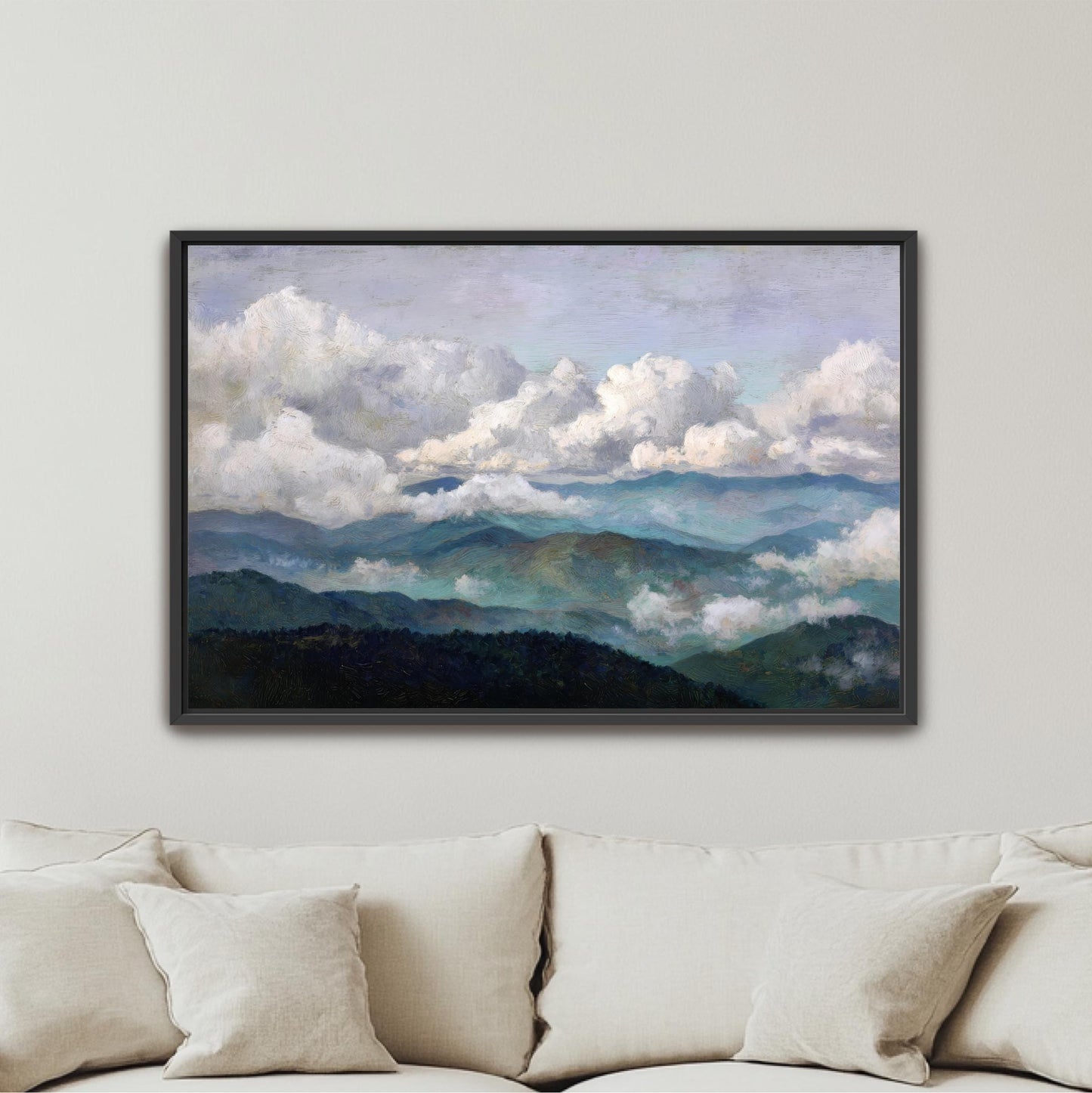 The image is a framed painting of a mountainous landscape with clouds, hanging on a wall above a couch.