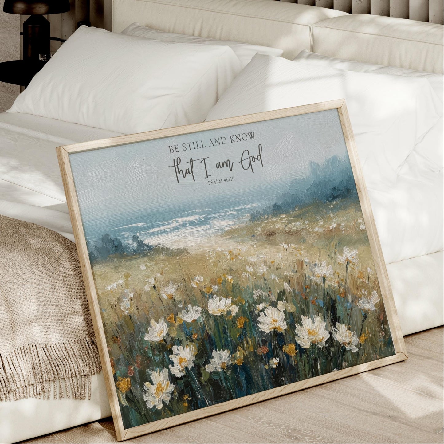 a framed painting of a field of flowers, with a text overlay that reads "Be Still and Know that I am God" and " Psalm 46:10".