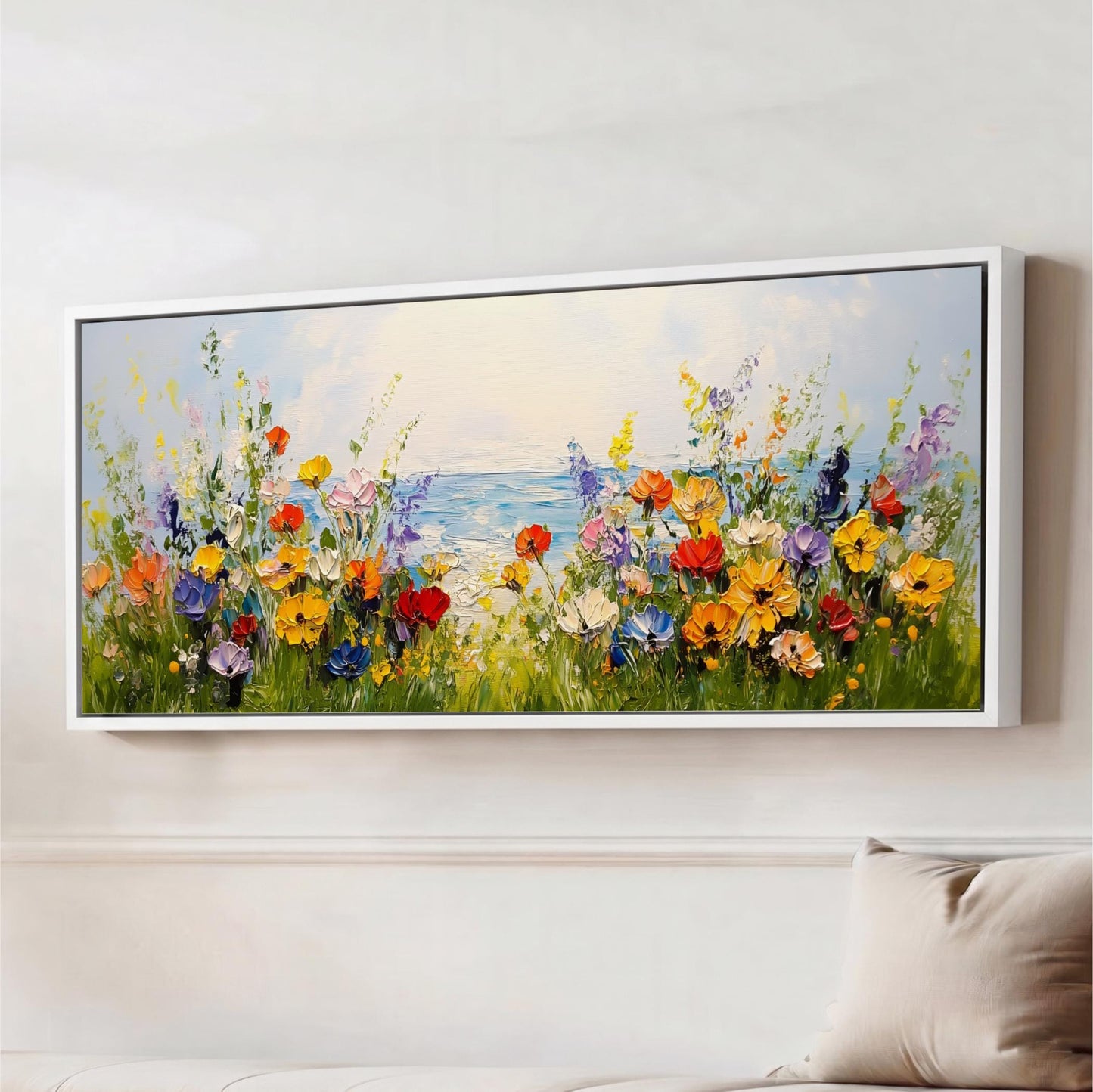 A large framed painting depicting a vibrant field of colorful flowers, with a body of water in the background.