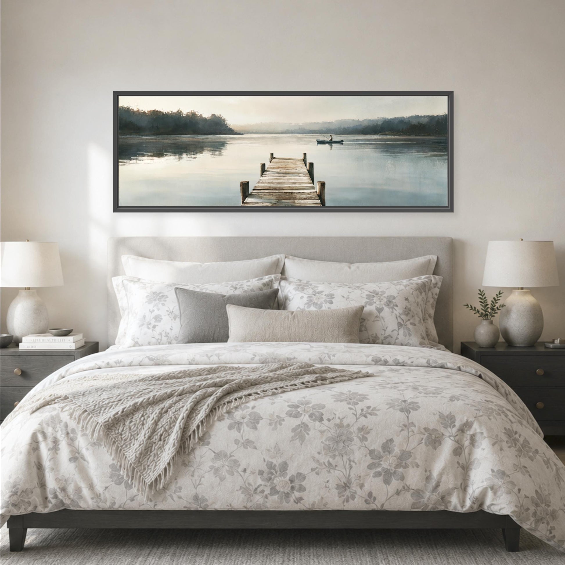 a large bedroom with a bed, nightstands, and a framed landscape painting depicting a dock leading to a lake.