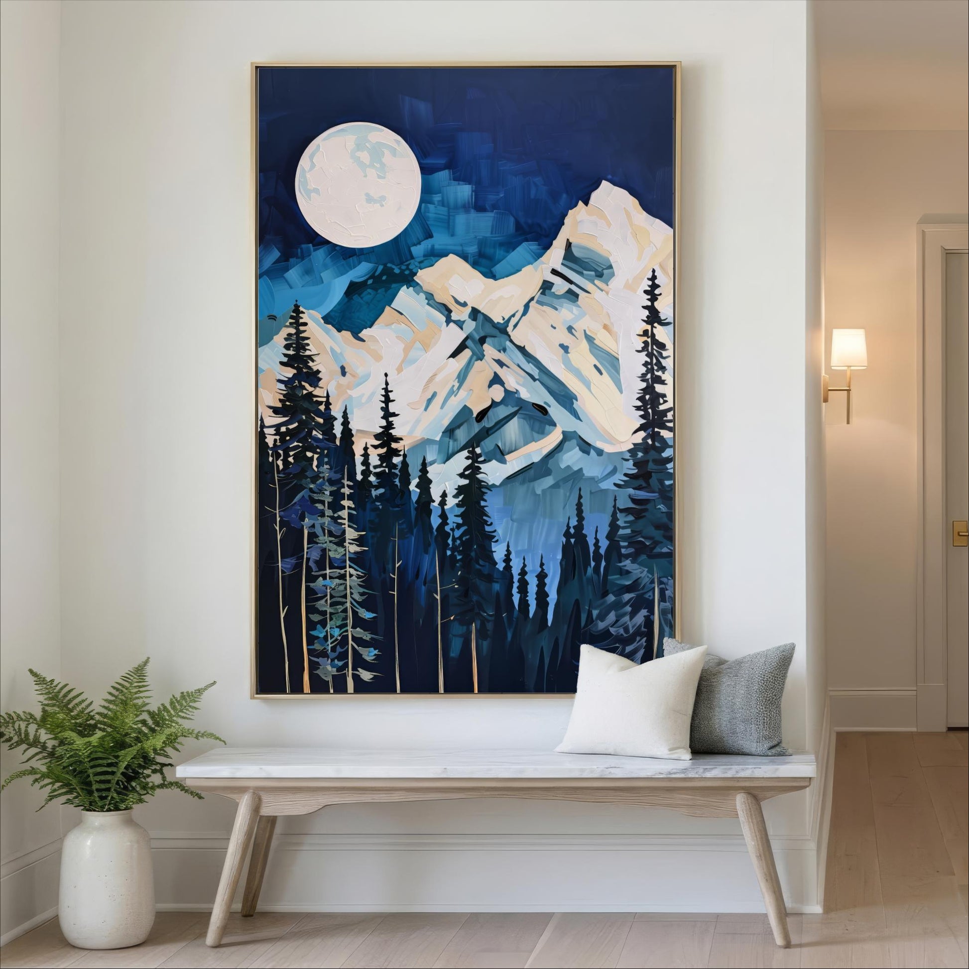 a large painting of a mountain landscape with a full moon in the night sky, hanging on a wall above a wooden bench with two pillows.