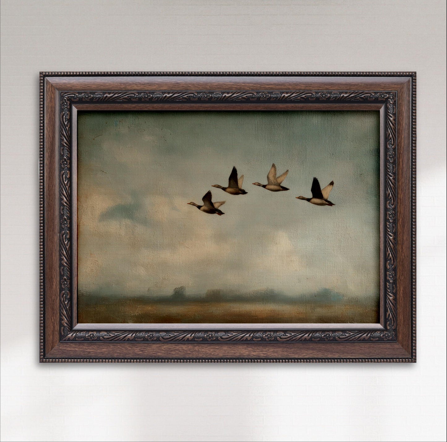 A framed painting depicting four ducks flying in formation against a cloudy sky.