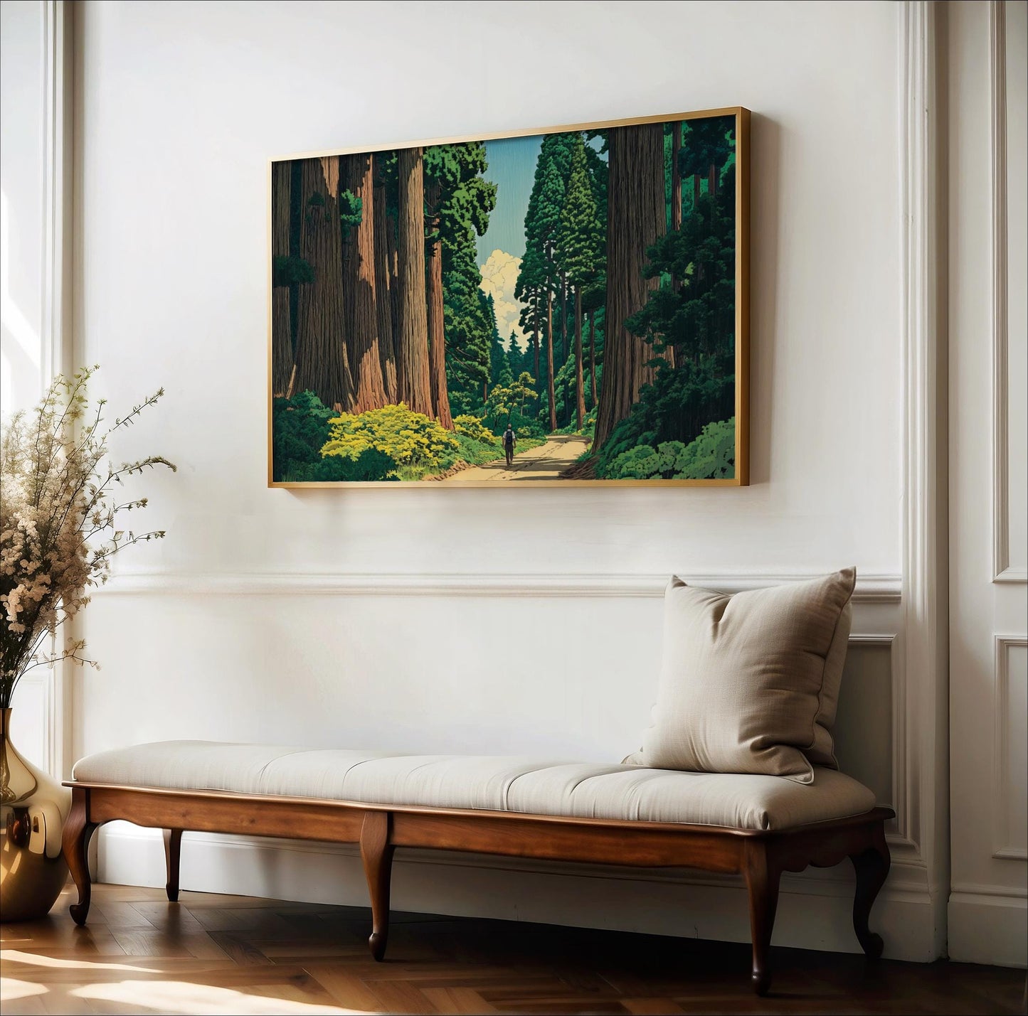 a large painting of a forest scene hanging on a white wall above a wooden bench with a white cushion.