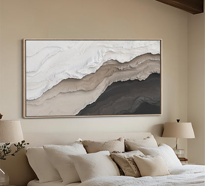 a large, abstract painting hanging on a wall above a bed with white bedding and pillows.