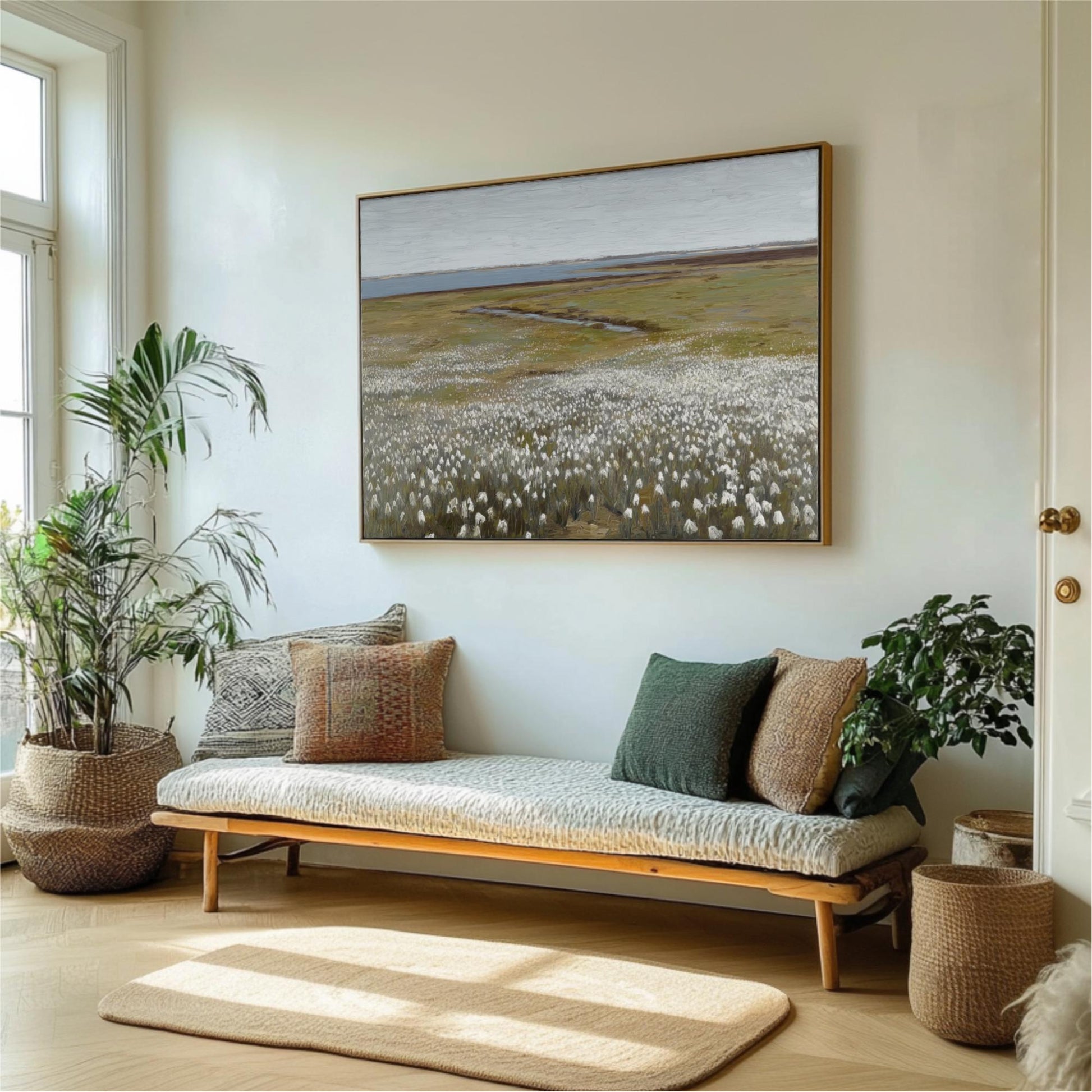 a living room with a large painting of a field of flowers hanging on the wall above a couch with pillows. The room is decorated with potted plants and a rug, creating a cozy and inviting atmosphere.