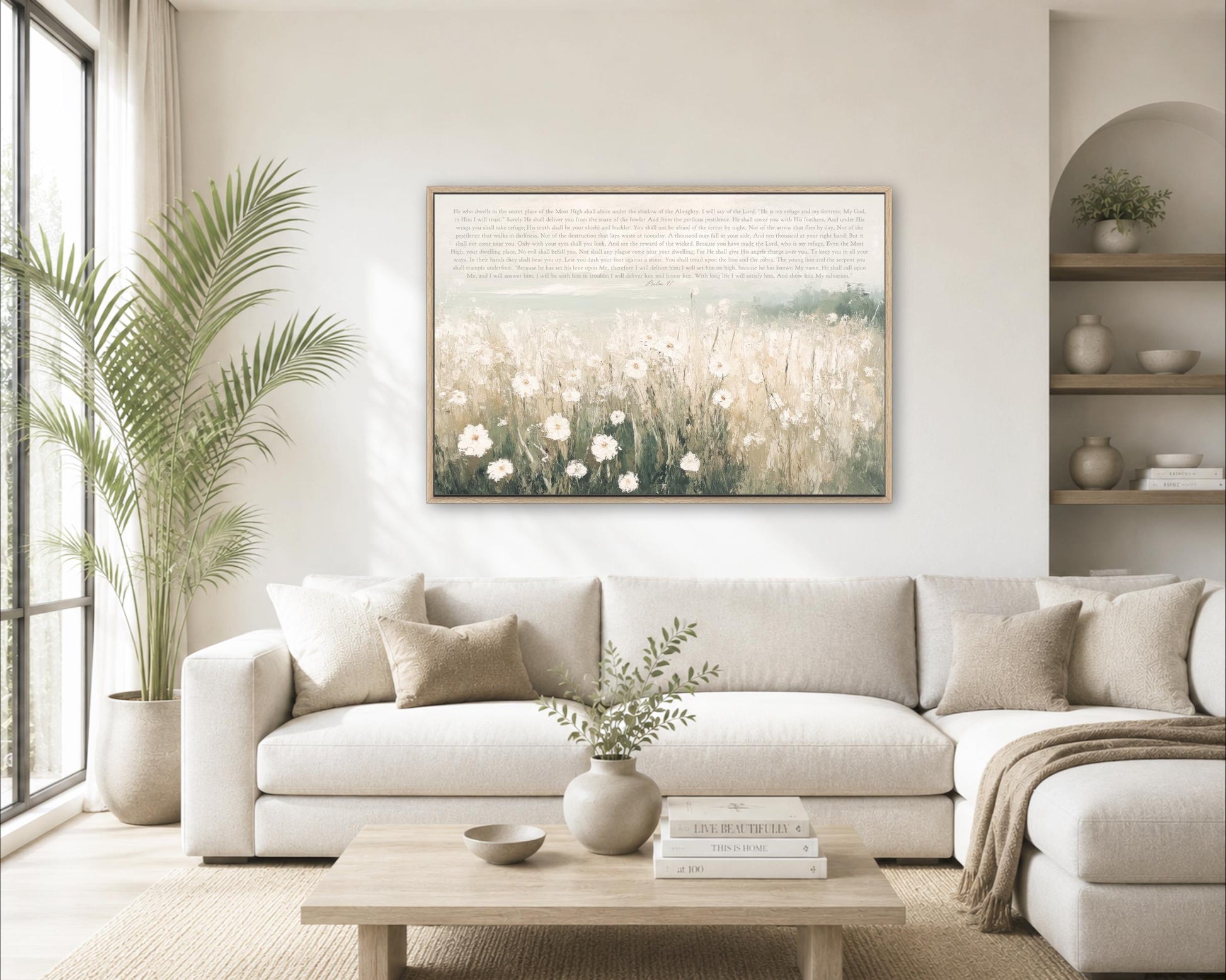 a cozy living room with a large white sofa, a wooden coffee table, and a framed painting of a field of flowers hanging on the wall.