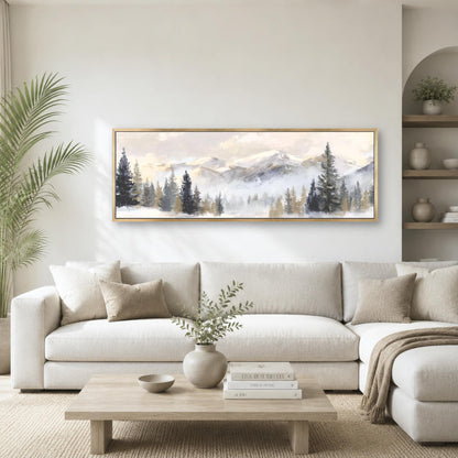 a living room with a large painting of a mountain landscape hanging on the wall above a white sofa. The sofa is positioned in front of a coffee table, which has a vase of greenery and a stack of books on it. The room also includes a potted plant and a bookshelf, creating a cozy and inviting atmosphere.