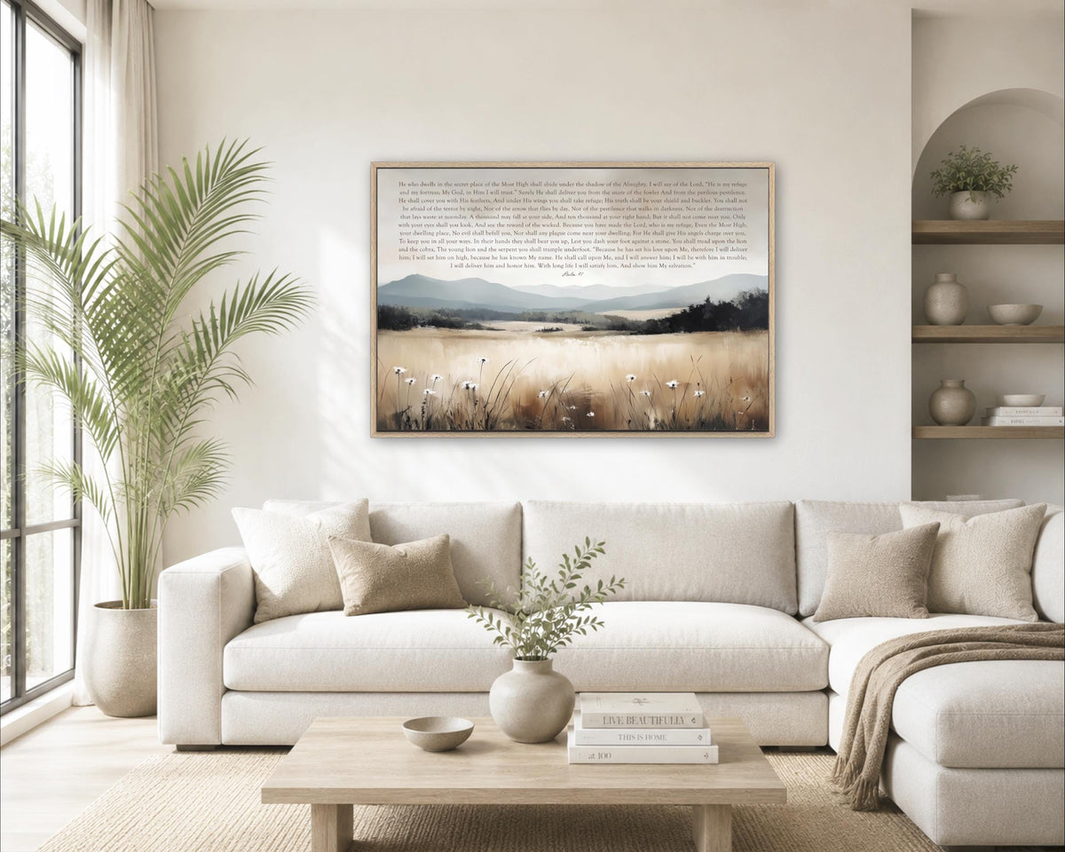 a cozy living room with a large white sofa, a wooden coffee table, and a framed landscape painting hanging on the wall above the sofa.