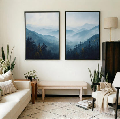 a cozy living room with two large framed landscape paintings hanging on the wall, depicting a serene mountain scene. The room is furnished with a white sofa, a wooden side table, and a beige armchair, creating a warm and inviting atmosphere. The room is also adorned with several potted plants, adding a touch of greenery and natural beauty to the space.