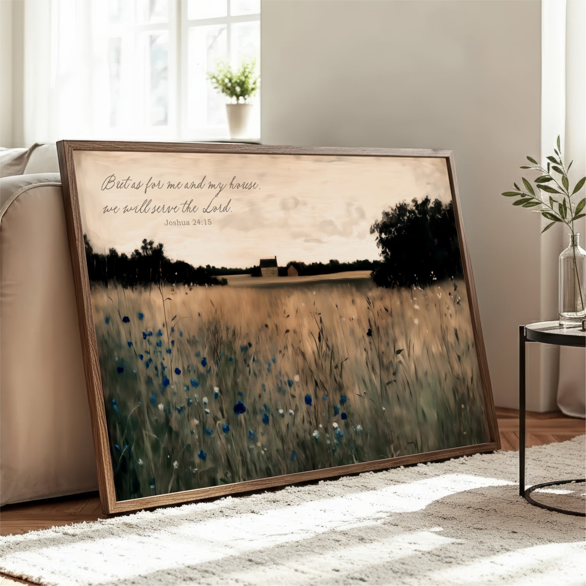 A framed painting depicting a serene landscape with a field of tall grass and trees, accompanied by a Bible verse from Joshua 24:15.