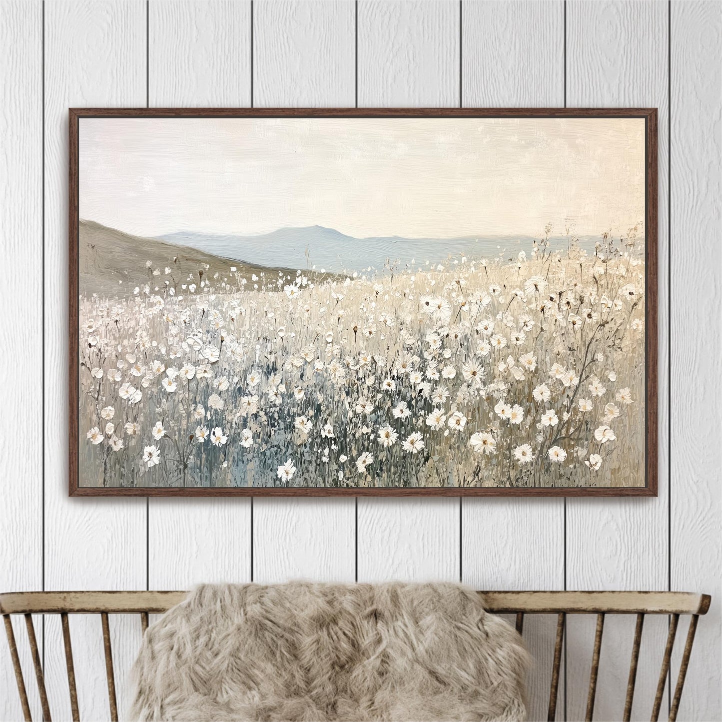 a large painting of a field of white flowers hanging on a wall above a wooden chair.