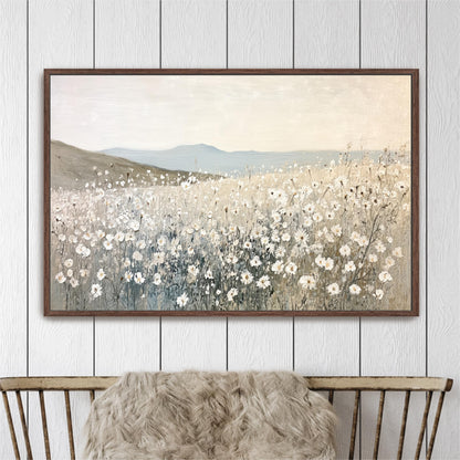 a large painting of a field of white flowers hanging on a wall above a wooden chair.