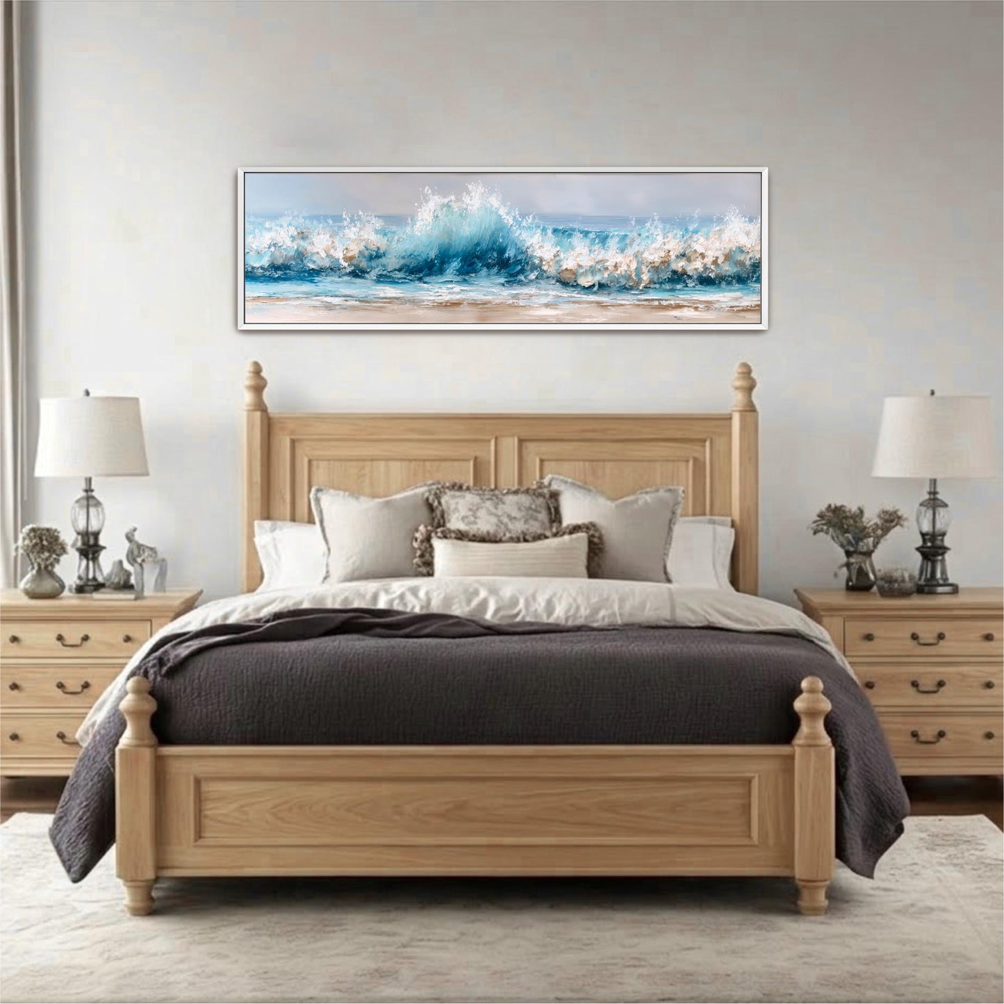 a large wooden bed with a gray comforter and pillows, positioned in front of a large window. Above the bed, there is a framed painting depicting a crashing wave. The room has a neutral color scheme with white walls and a gray carpet.