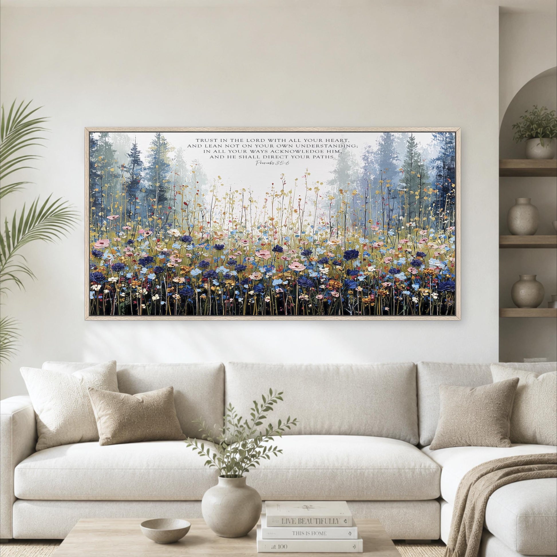 a large, framed painting of a field of flowers hanging on a wall above a white couch in a living room.