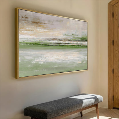 a large, abstract painting hanging on a wall above a gray bench in a hallway.