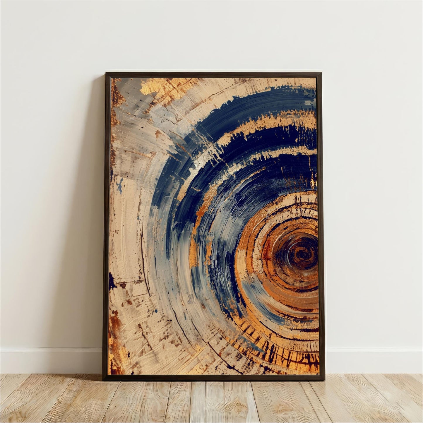 a large abstract painting with a circular pattern in shades of blue, orange, and brown. The painting is framed and displayed on a wooden floor against a white wall.