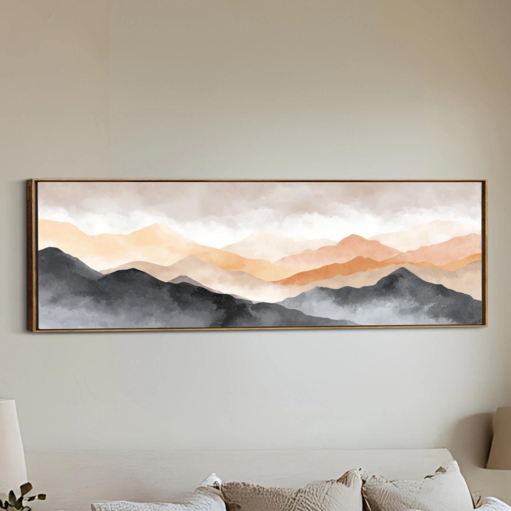 a large, framed painting of a mountain landscape hanging on a wall.