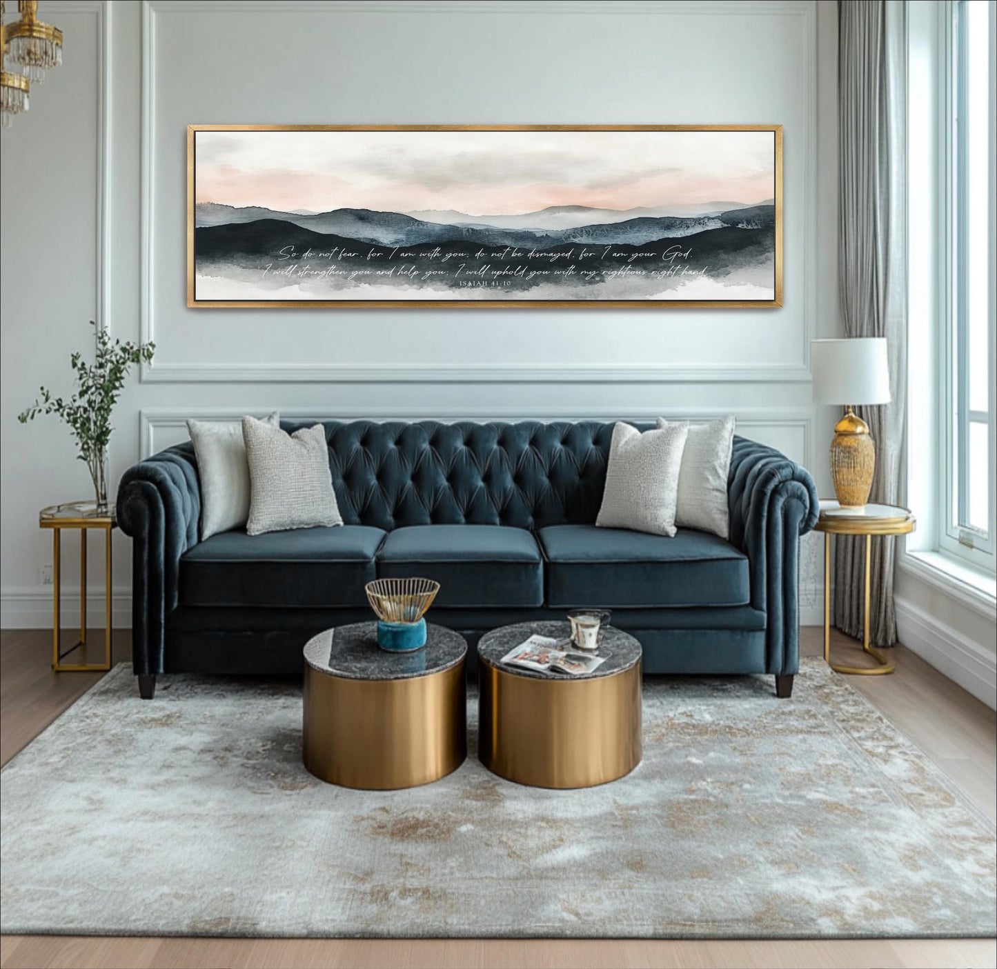 A modern living room with a blue tufted sofa, two round coffee tables, and a large framed landscape painting on the wall.