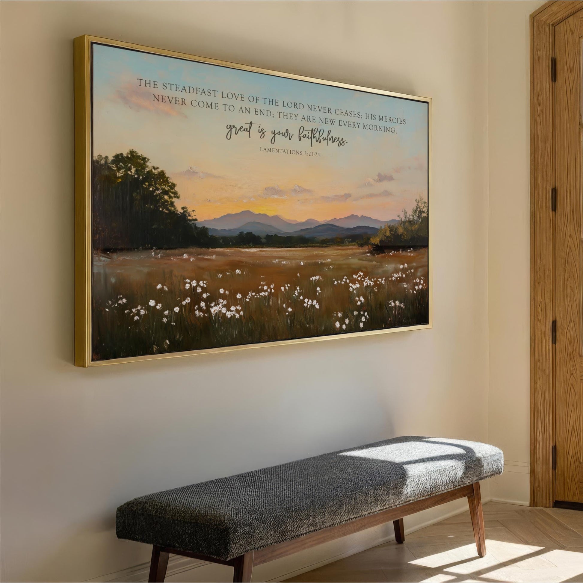 a large framed painting of a serene landscape with a field of flowers and mountains in the background, hanging on a wall.