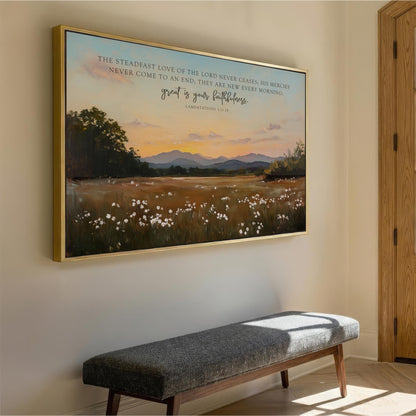 a large framed painting of a serene landscape with a field of flowers and mountains in the background, hanging on a wall.