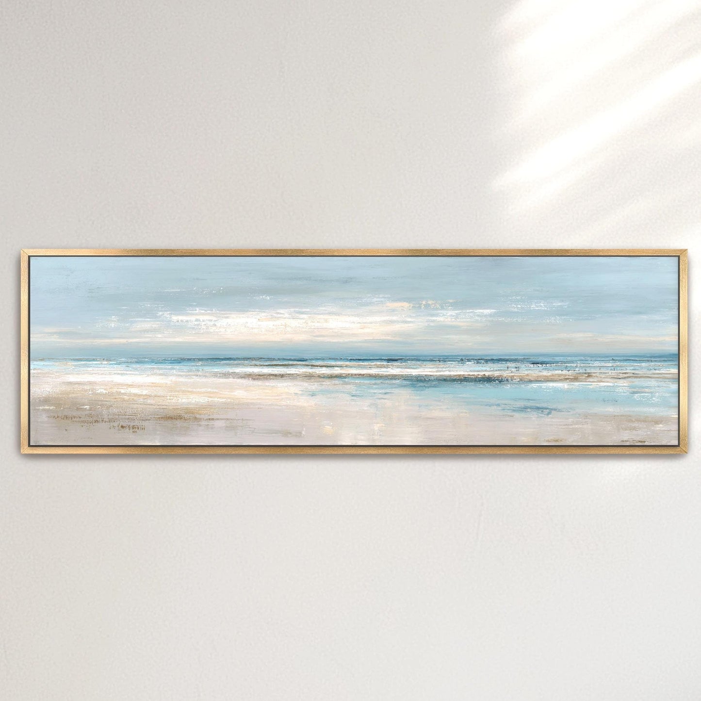 A framed painting depicting a serene beach scene with a calm ocean and a light blue sky.