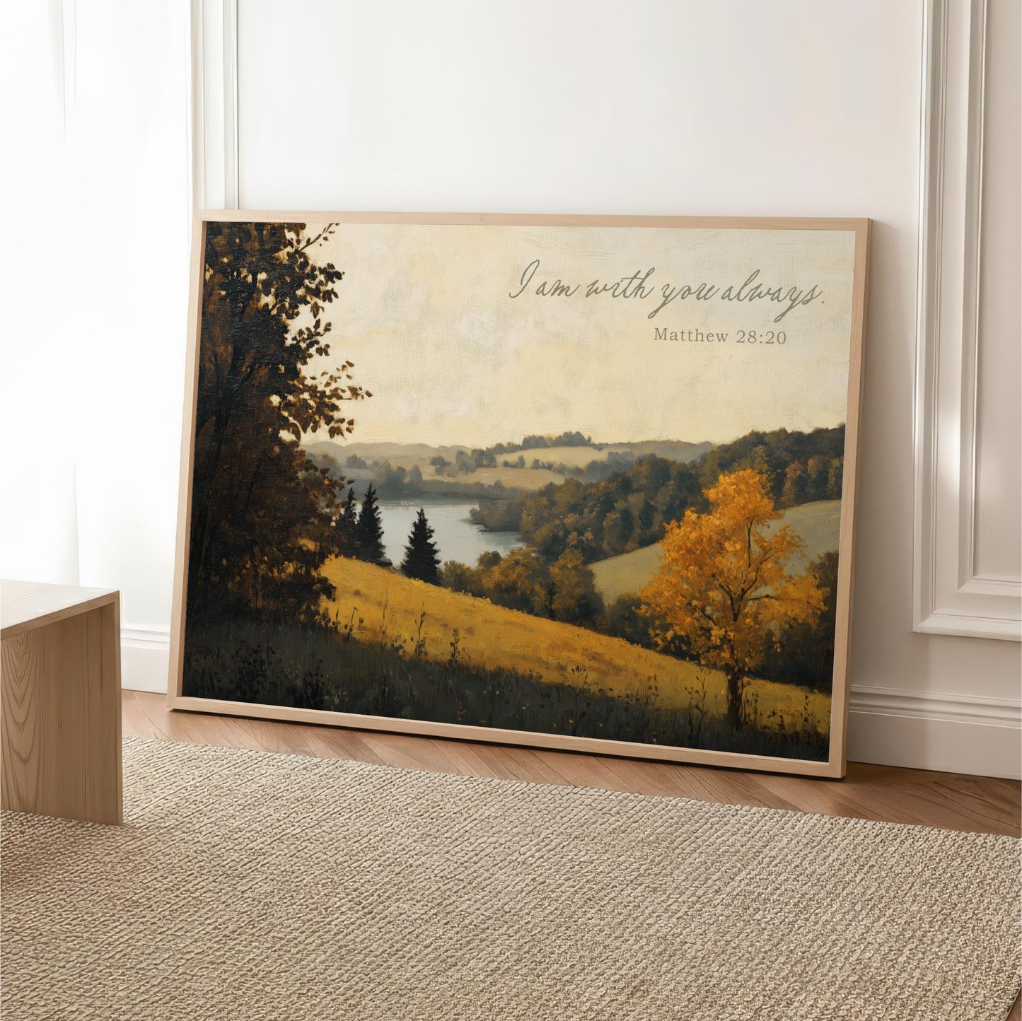 A framed painting depicting a serene landscape with a tree and a body of water, accompanied by the text "I am with you always" and a Bible verse reference.
