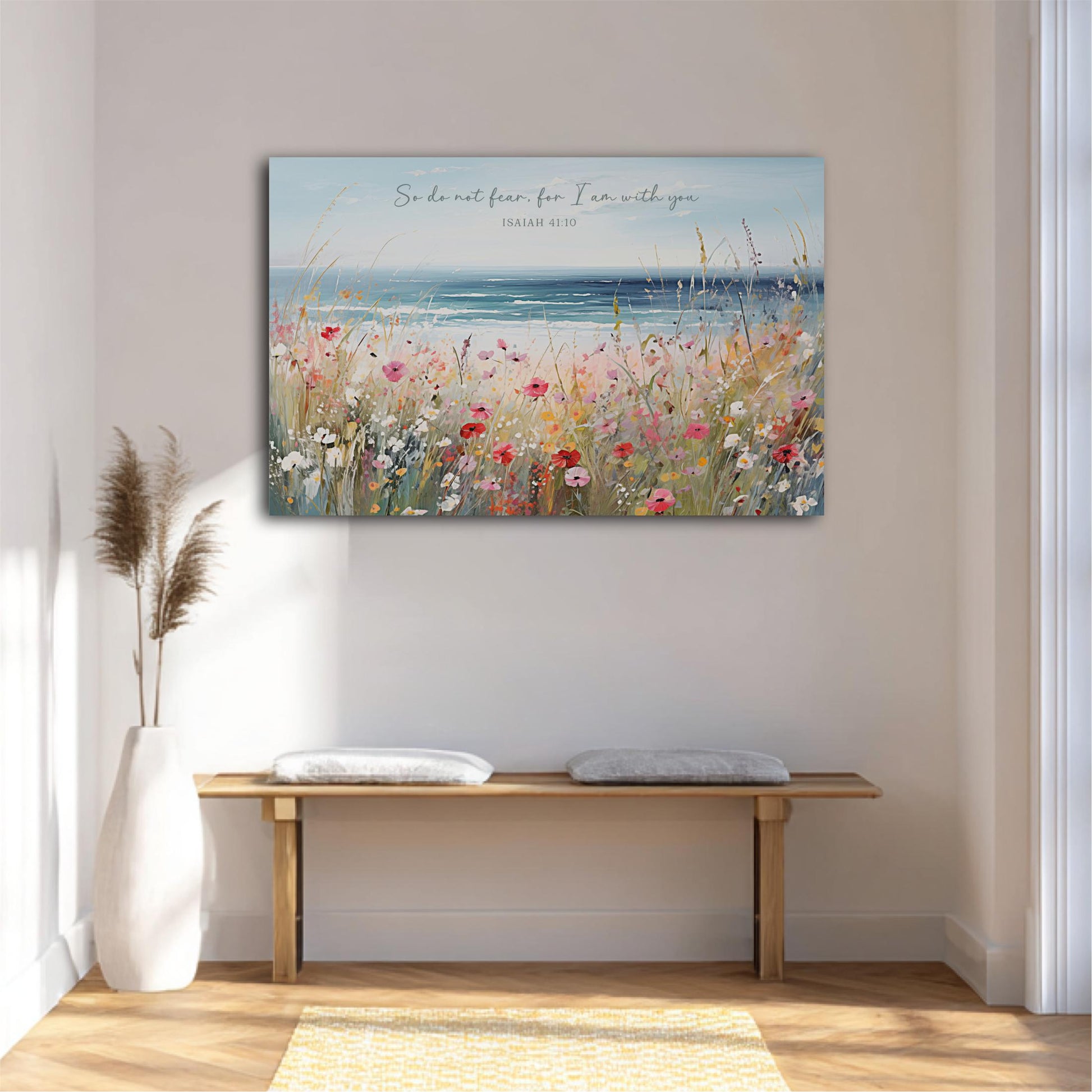 a serene indoor setting with a wooden bench, a white vase, and a potted plant. Above the bench, there is a large painting depicting a field of flowers and a body of water, with the text "So do not fear, I am with you" written above it.
