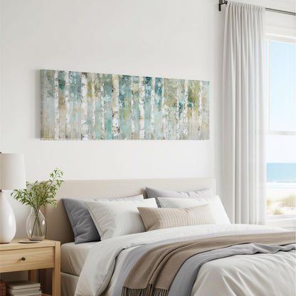 a serene bedroom scene with a large painting of trees hanging on the wall above a bed with white bedding and a gray throw blanket.