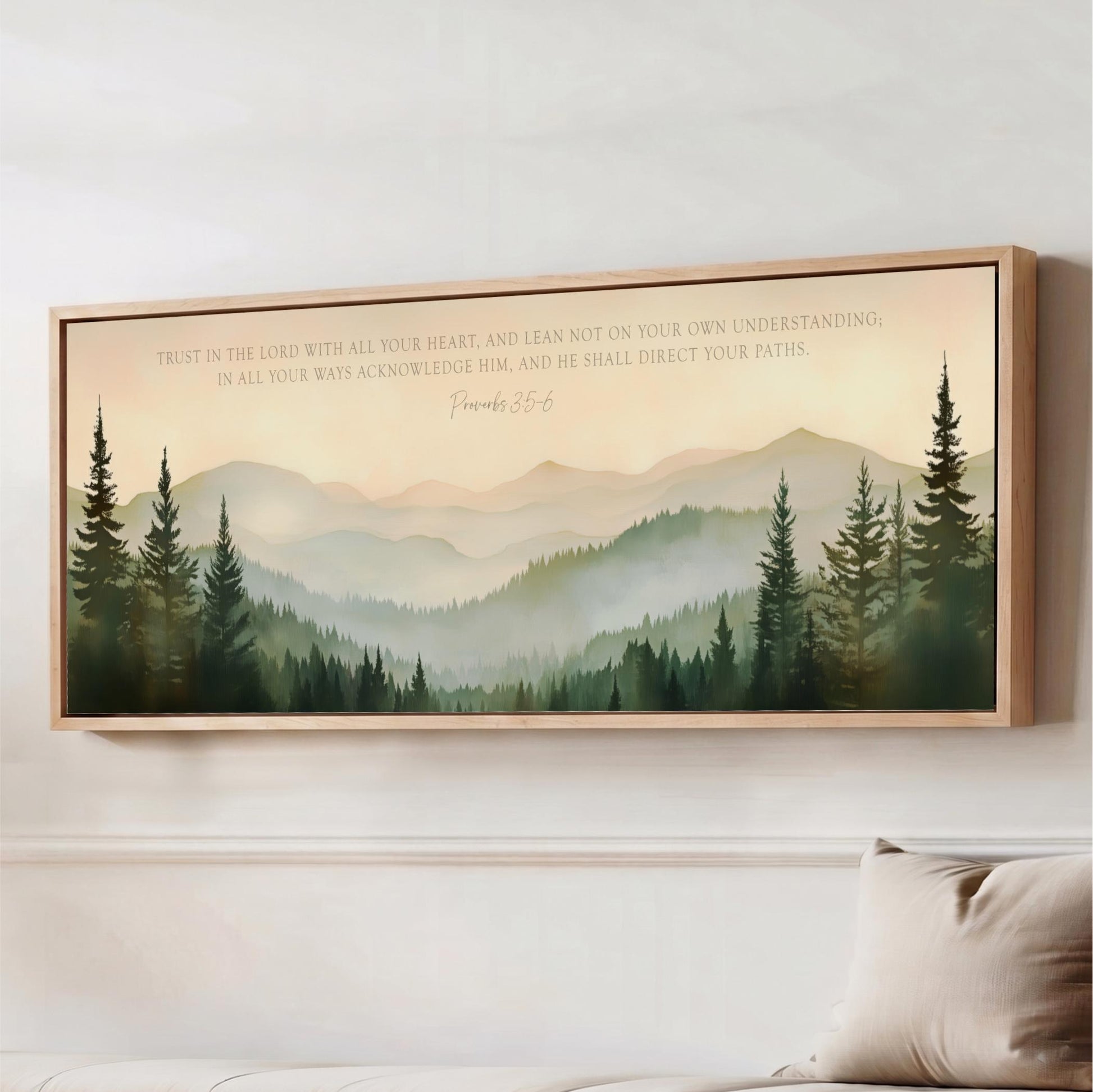 The image is a framed painting of a mountain landscape with pine trees, hanging on a wall above a couch.
