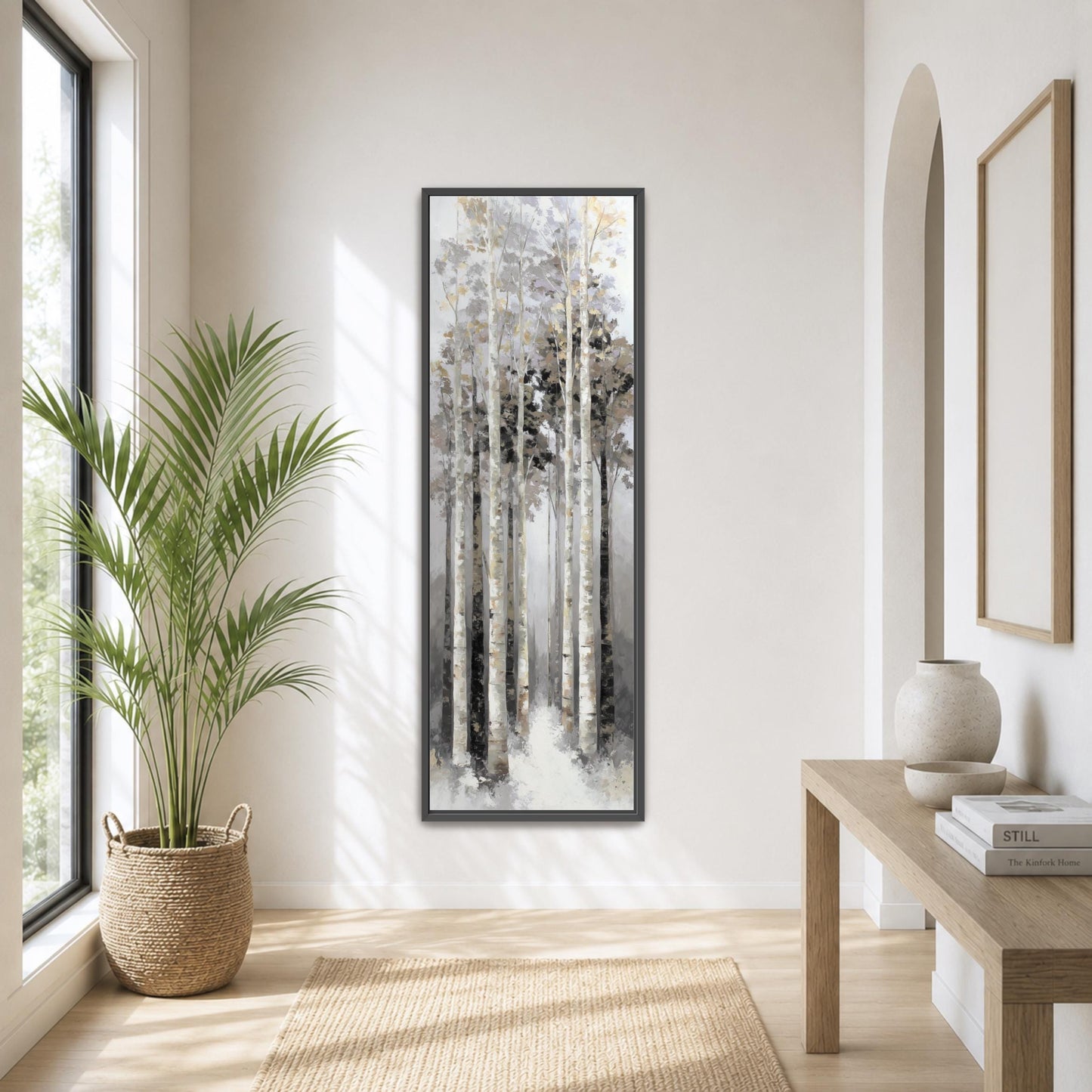 a serene and minimalist living room with a large window, a wooden table, a potted plant, and a framed painting of a forest scene.