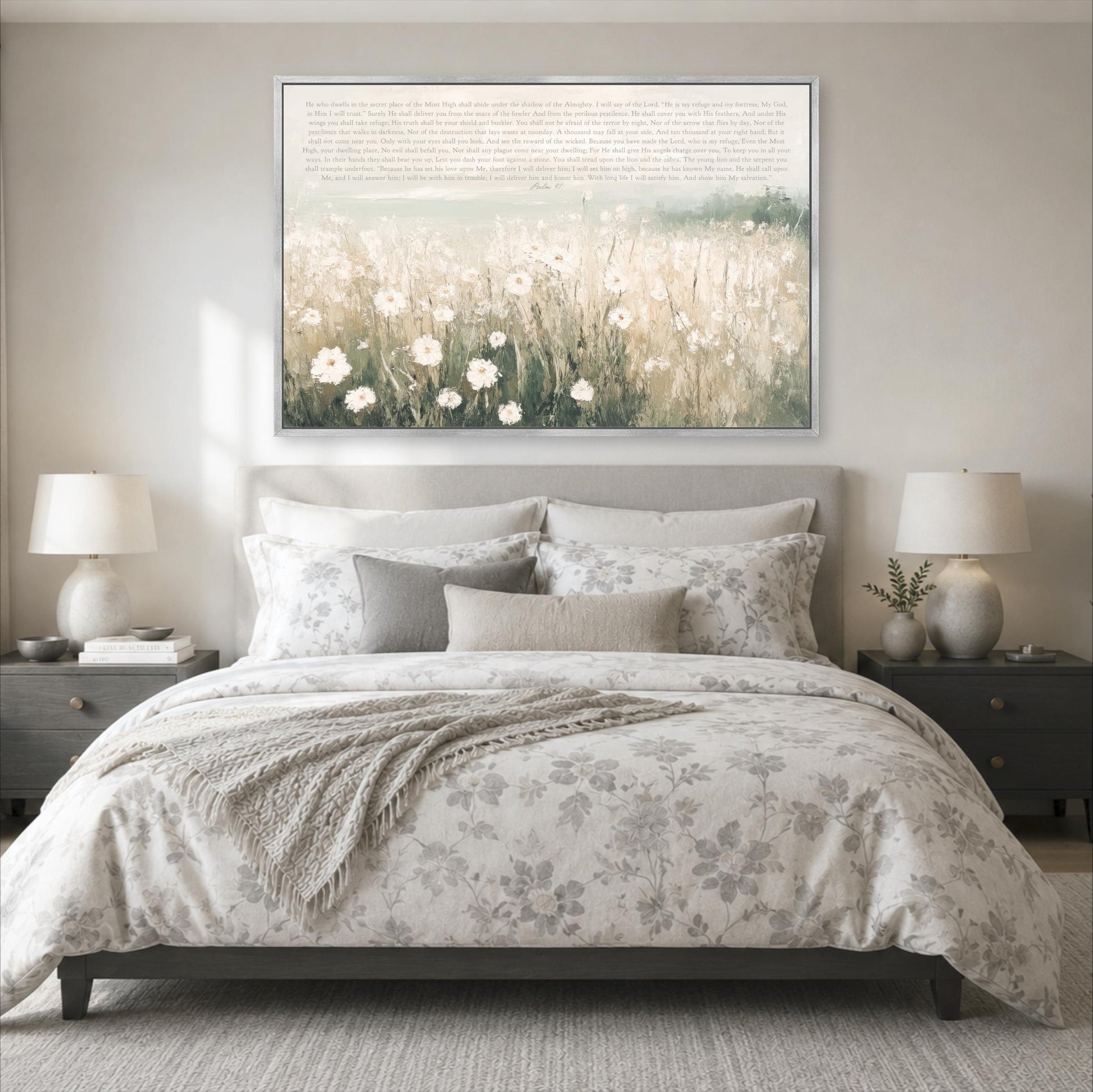 a serene bedroom scene with a large bed adorned with a floral comforter and pillows, flanked by two nightstands with lamps. Above the bed, a large framed print of a field of flowers serves as a focal point in the room.